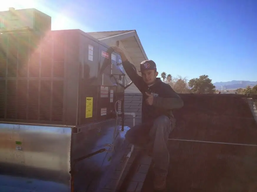 HVAC technician performing Boiler Repair on a rooftop unit in Lynnfield